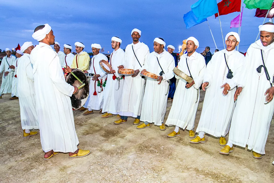 Rang de danseurs d'ahwach en tenue blanche jouant du bendir, la danse des fêtes berbères