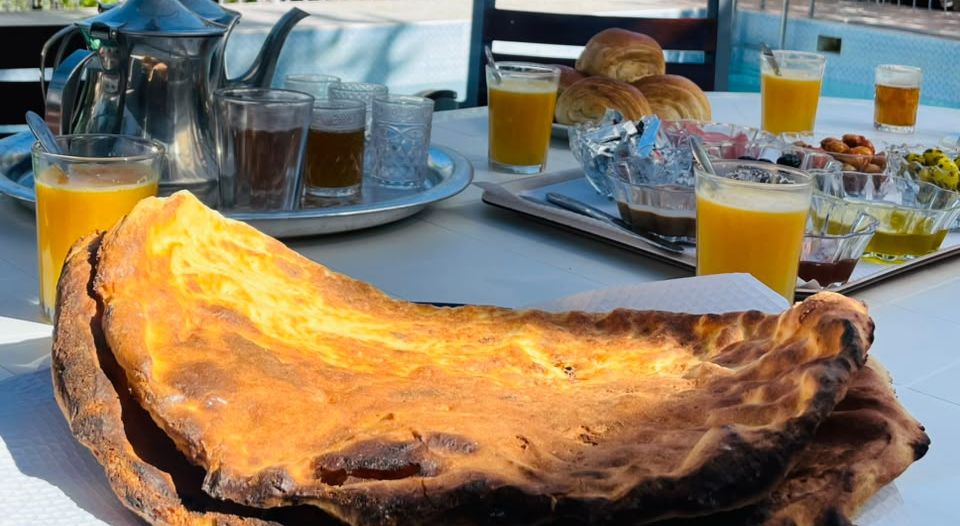 Ftour beldi by the guesthouse pool: tafarnout bread baked on river stones, tea, orange juice and croissants
