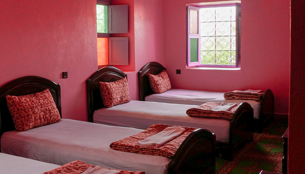 Family room with pink walls and several single beds