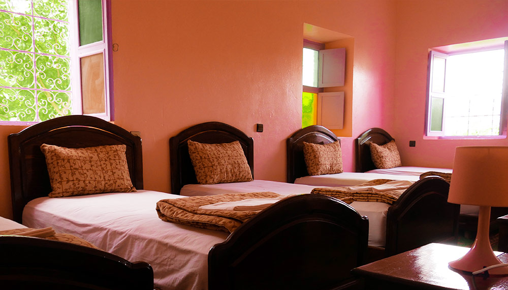 Bright family room with orange walls and several wooden beds