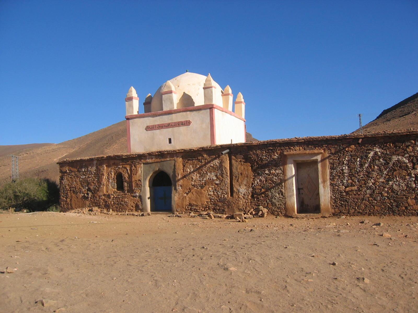 Le marabout de Lalla Myriam à Tagmoute : coupole blanche bordée de rose, murs de pierre et de terre, porte bleue