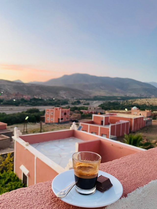 Un café sur la terrasse de l'auberge, face au village de Tagmoute et aux montagnes au coucher du soleil