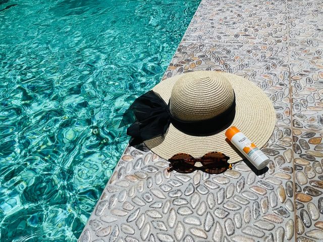 Chapeau de paille et lunettes de soleil au bord de la piscine de l'auberge, à Tagmoute
